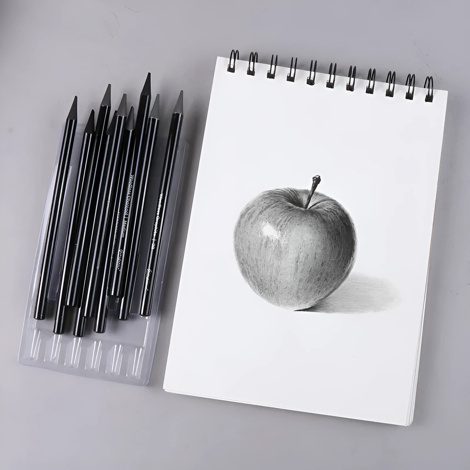 Set of nine graphite and carbonised drawing pencils in wooden casings on a suction card.