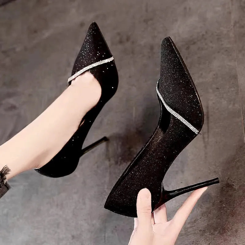 Women's black pointed toe stiletto high heels with a low-cut vamp on a white background