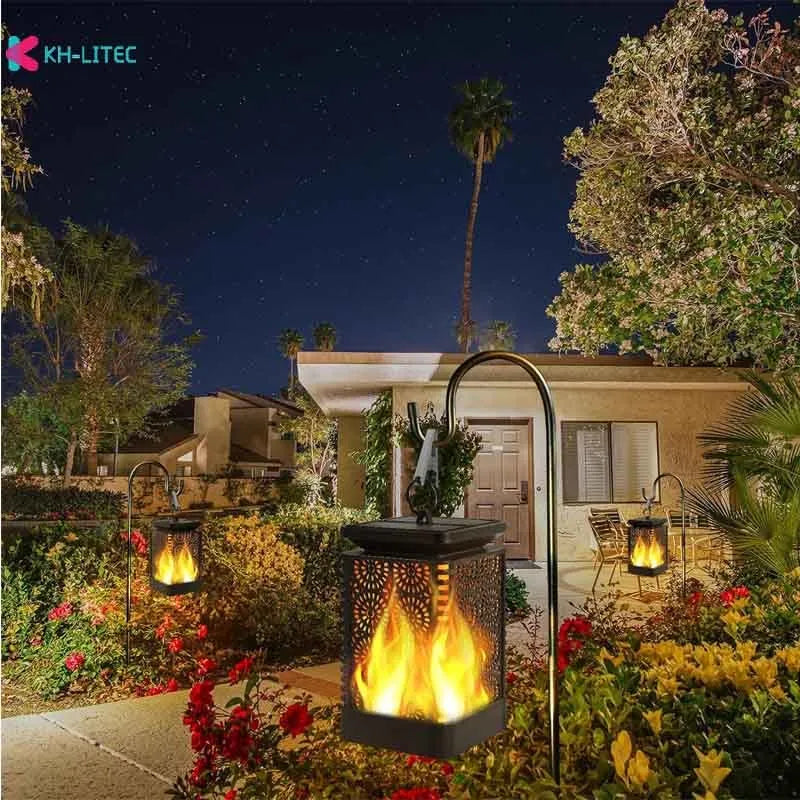 Set of four black solar-powered hanging torch lights with flickering flame LED effect in a garden setting