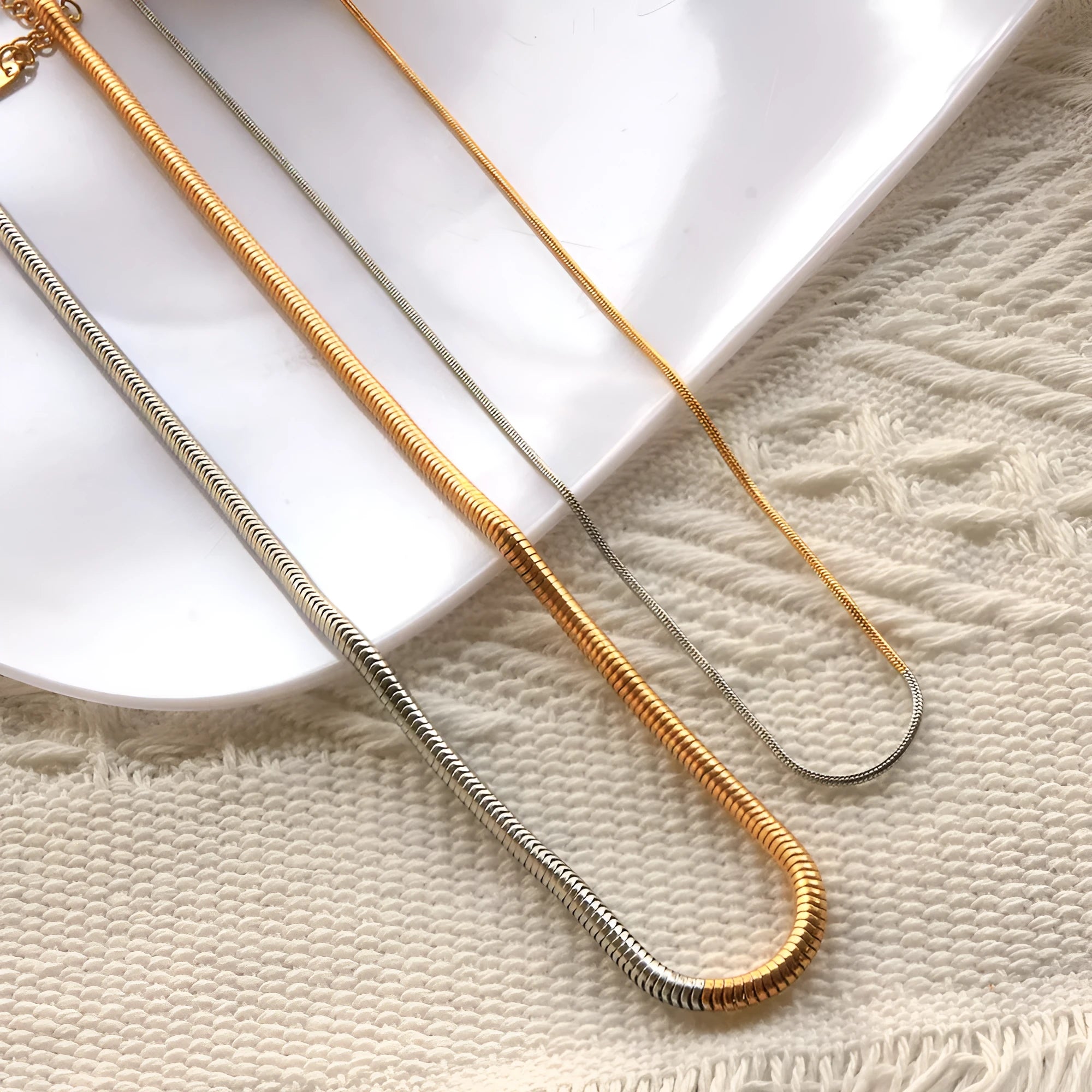 Gold-coloured stainless steel snake bone chain necklace with geometric design, 3mm width.