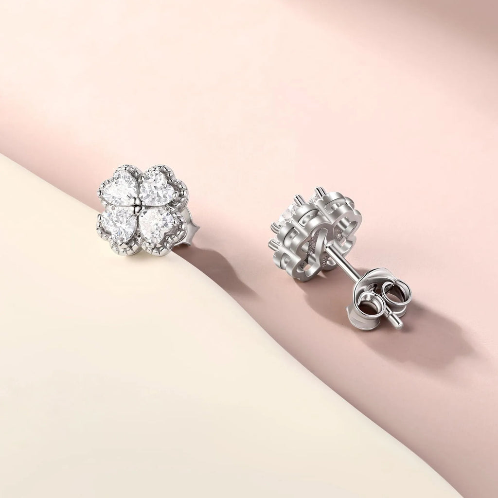 Close-up of women's white gold coloured heart shaped earrings with a four-leaf clover design, made from 925 silver and inlaid zircon stones.