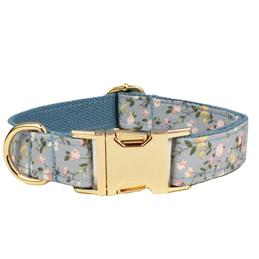 Blue floral patterned adjustable dog collar with matching leash, bow, and vest on a white background.