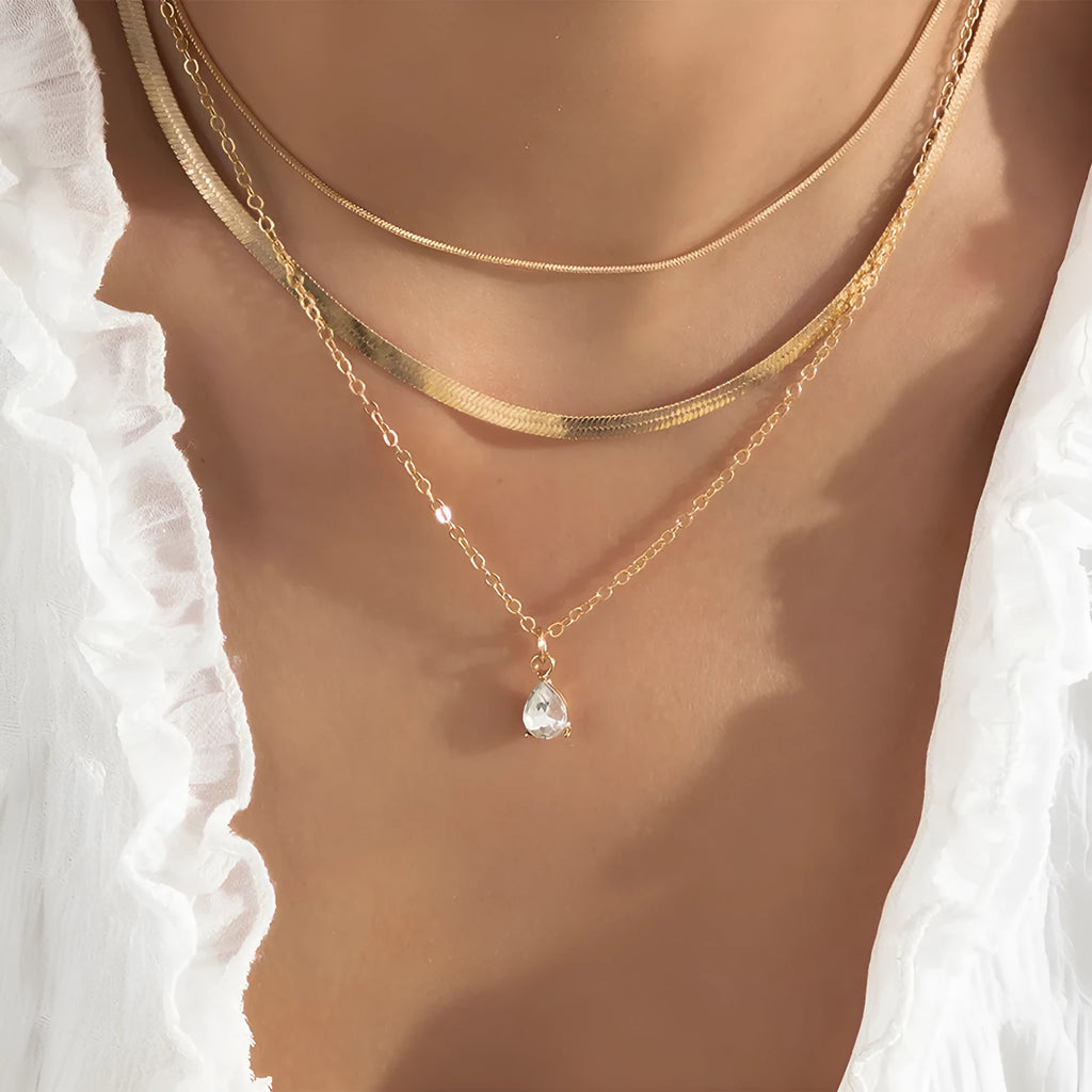 Gold and silver water drop shape alloy pendant necklace with electroplated finish on white background