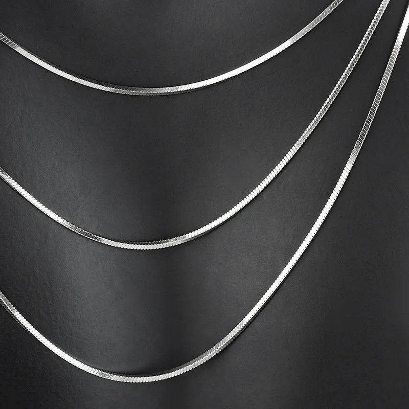 S925 sterling silver plated platinum necklace with fine snake bone chain in silver on neutral background