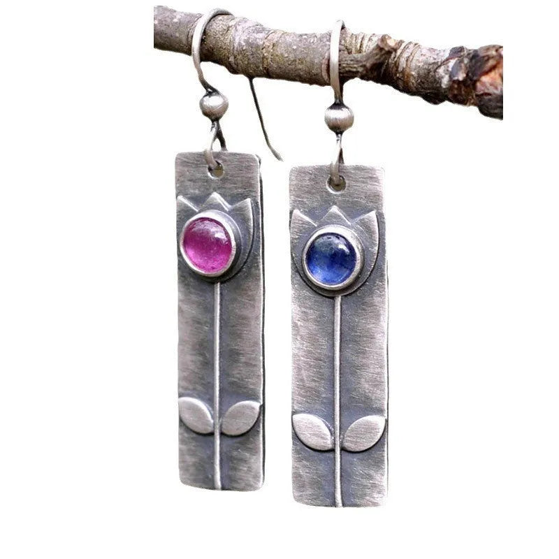 Antique finish metal stud earrings with a red sapphire in an ellipse shape, retro style.