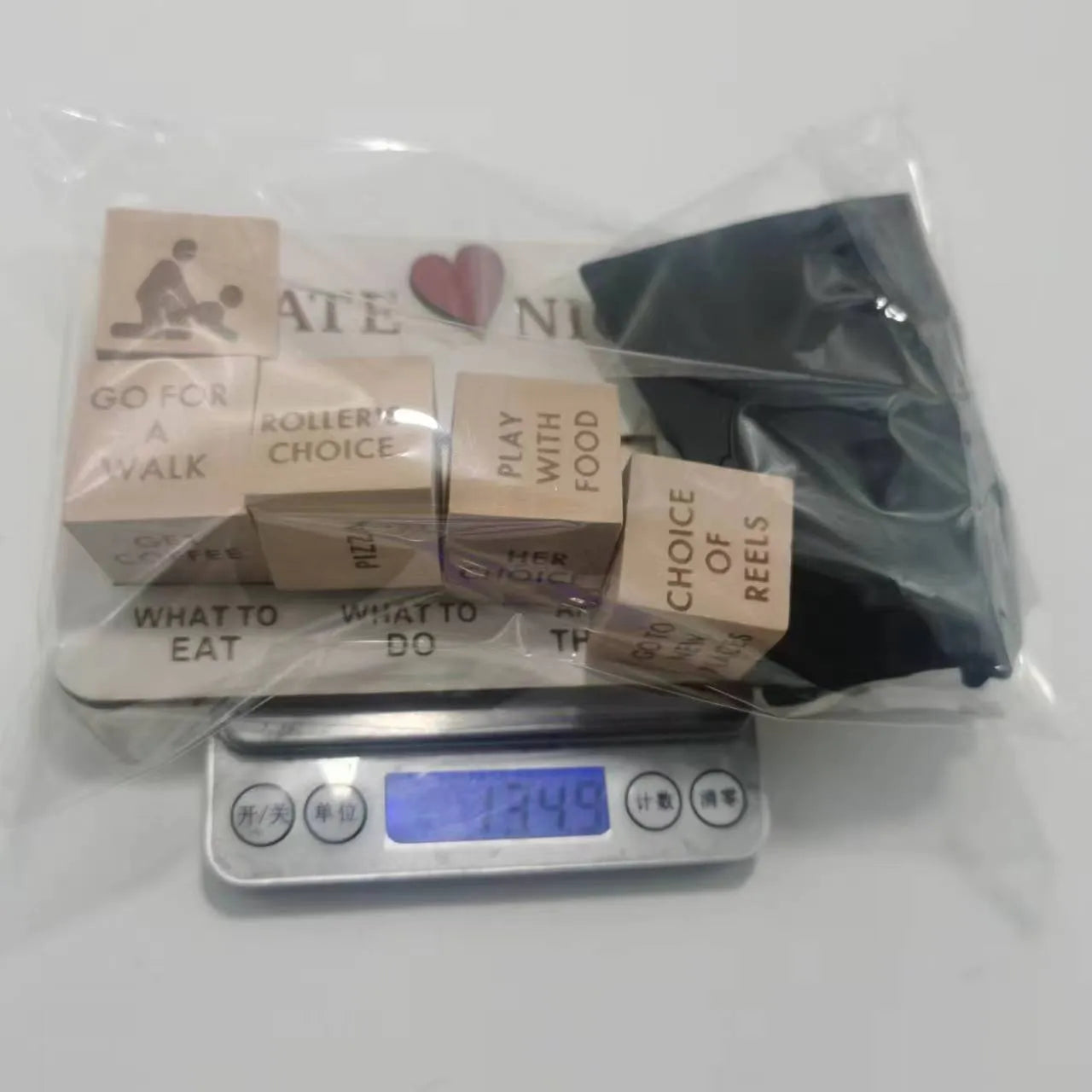 Wooden date night dice set with five natural wood dice on a rectangular planner board next to a black storage bag.