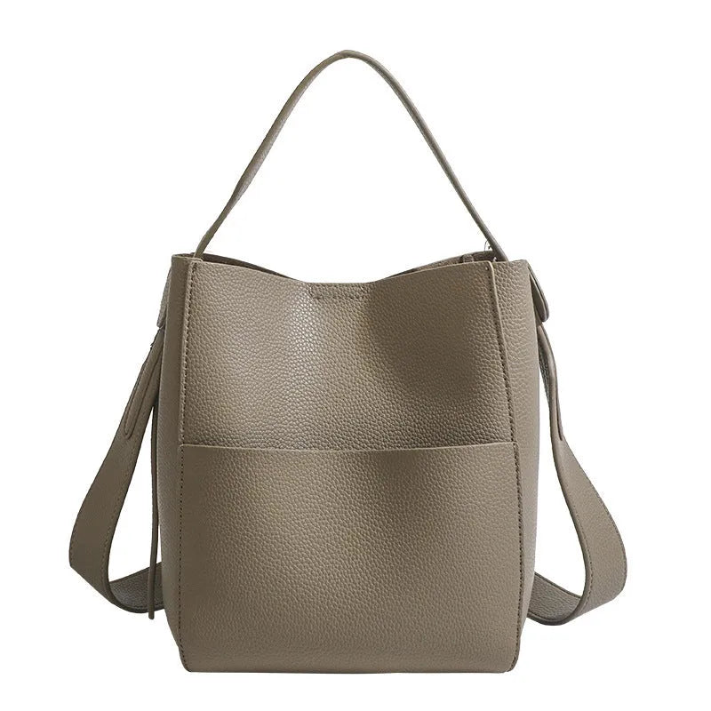 Soft PU bucket messenger bag in elephant gray with visible sewing line detailing, outer sandwich pocket, and single shoulder strap.