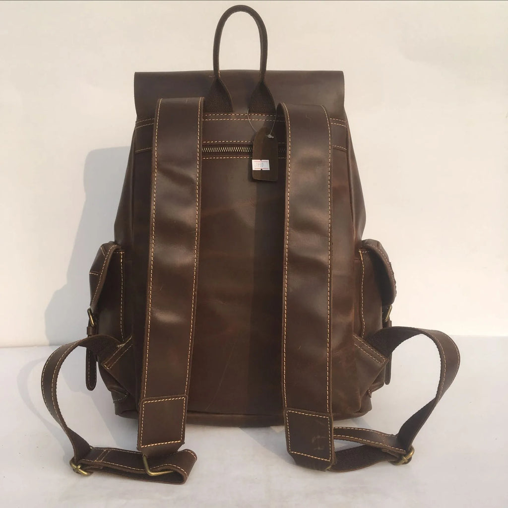 Brown men's leather backpack showing genuine cowhide material and integrated air pillow shoulder straps.
