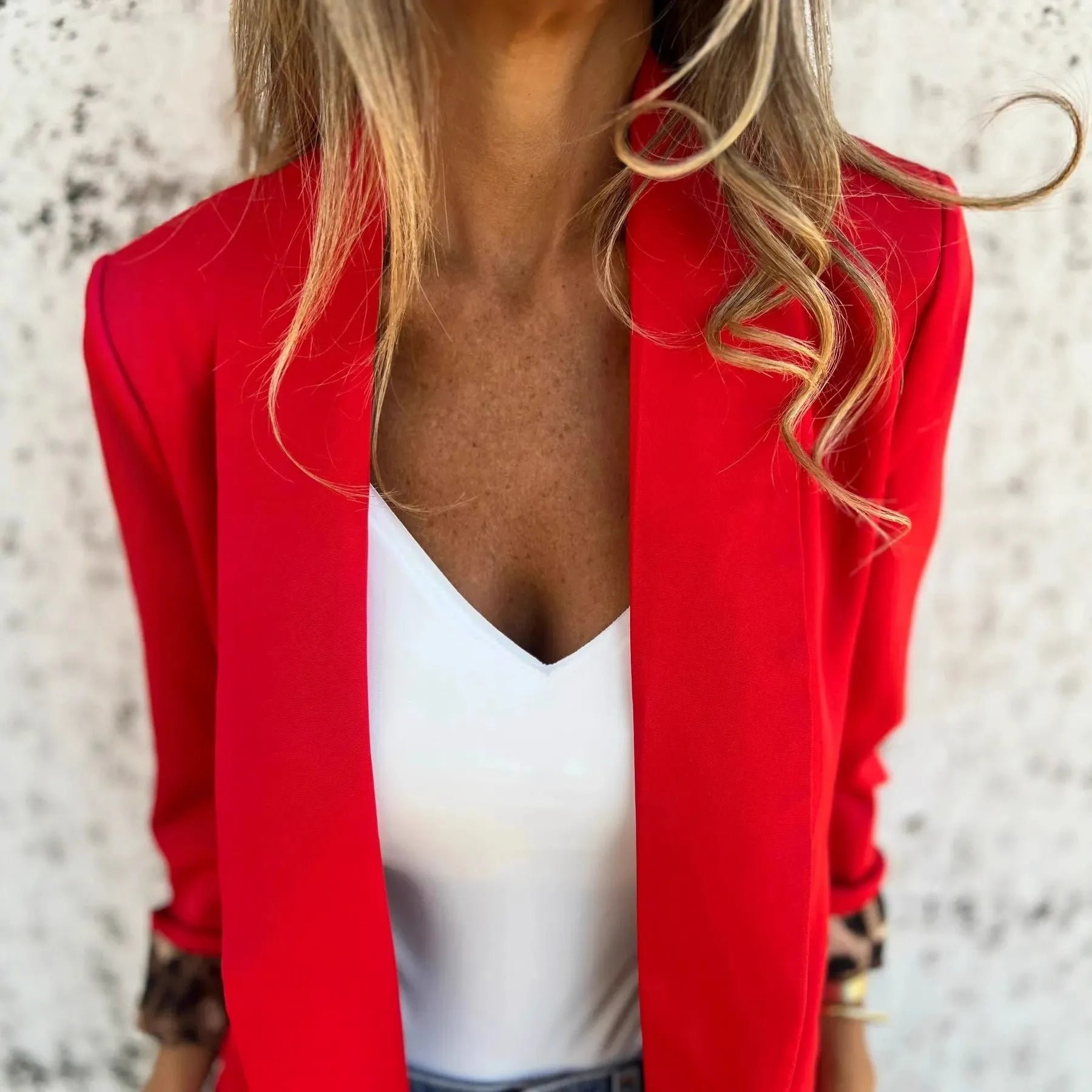 Woman wearing a slim fit black blazer with a bold 3D cheetah animal print pattern.