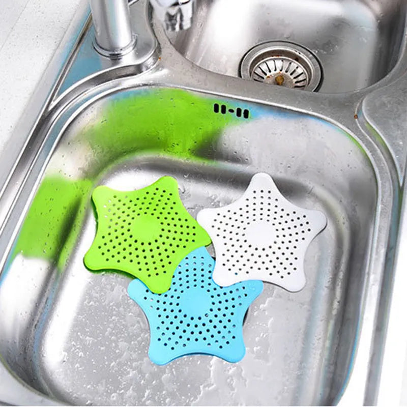 Three silicone starfish-shaped sink drain filters in white blue and green with suction cups