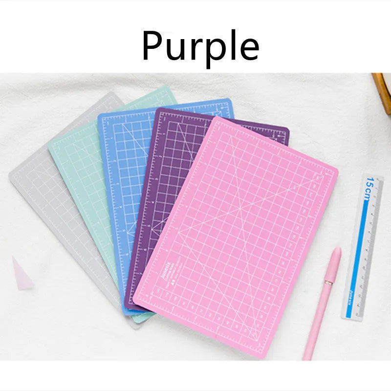 Art pen knife cutting board set in blue, showing plastic backing board with ruler, metal blade, and sharpener.
