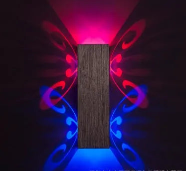 Colourful butterfly-shaped aluminium LED wall lamp mounted on a wall for accent lighting.