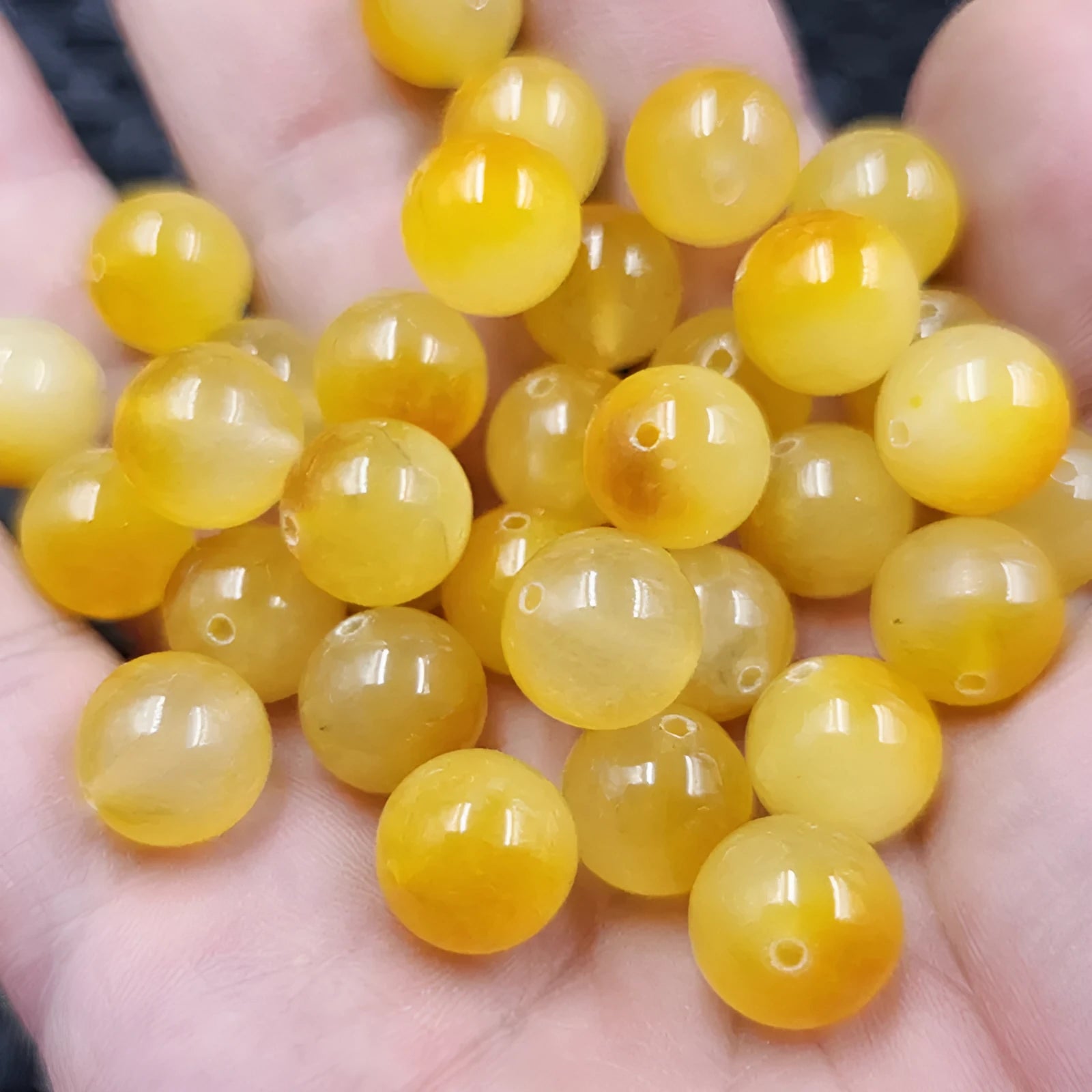 Handmade quartz rock jade bead in Topaz colour with pearlescent finish on white background