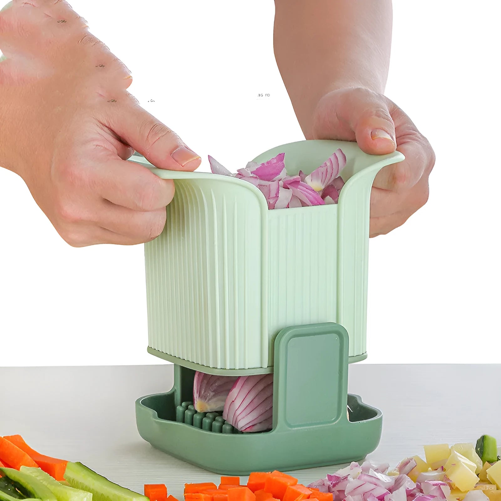Green multifunctional vegetable chopper with stainless steel blades for dicing onions and slicing cucumbers.