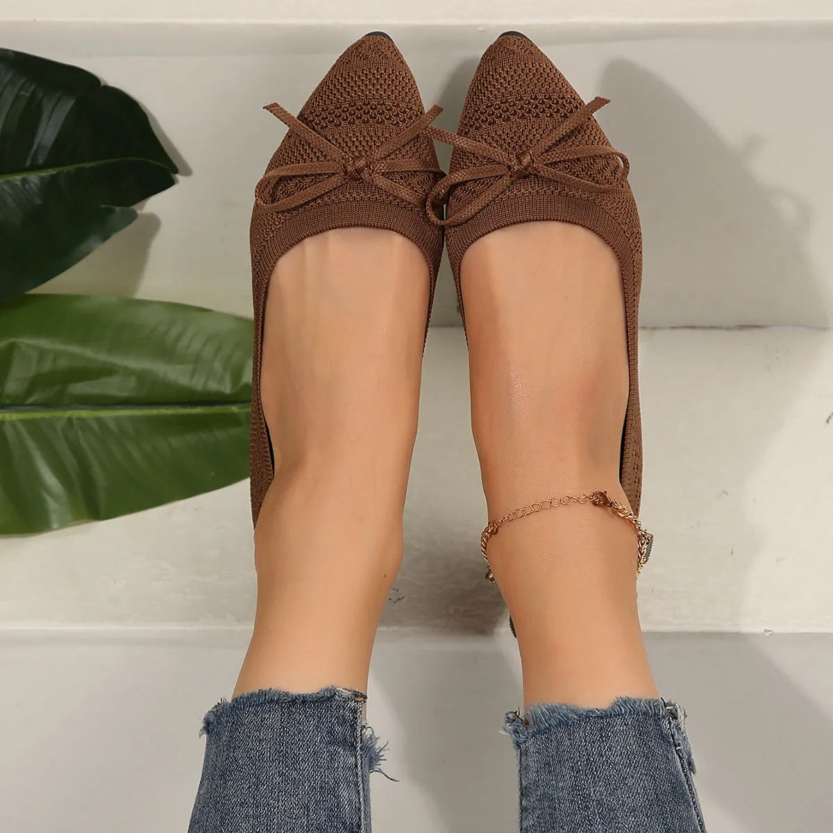 Women's blue knitted flat loafers with a bow and pointed toe on a rubber sole.