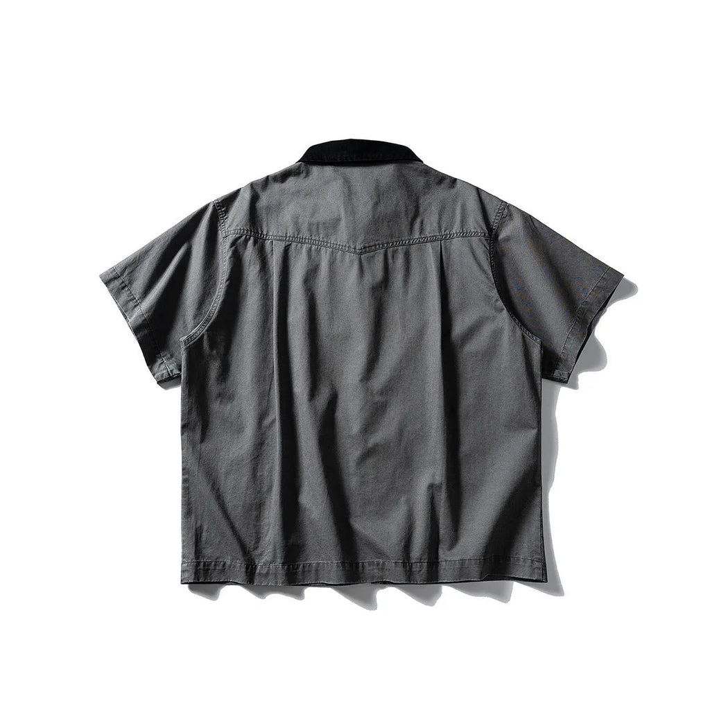 A khaki-coloured, short-sleeved overalls shirt with a loose cardigan style on a hanger.