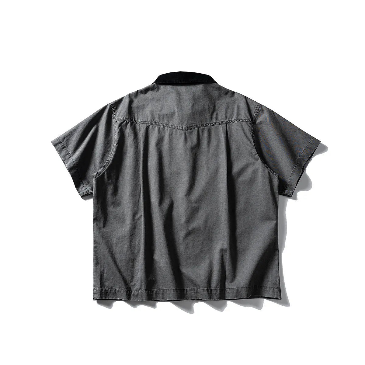 A khaki-coloured, short-sleeved overalls shirt with a loose cardigan style on a hanger.