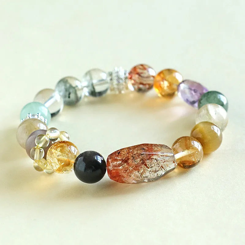 Close-up of a women's black and gold bracelet with natural Super Seven Duobao crystal beads.