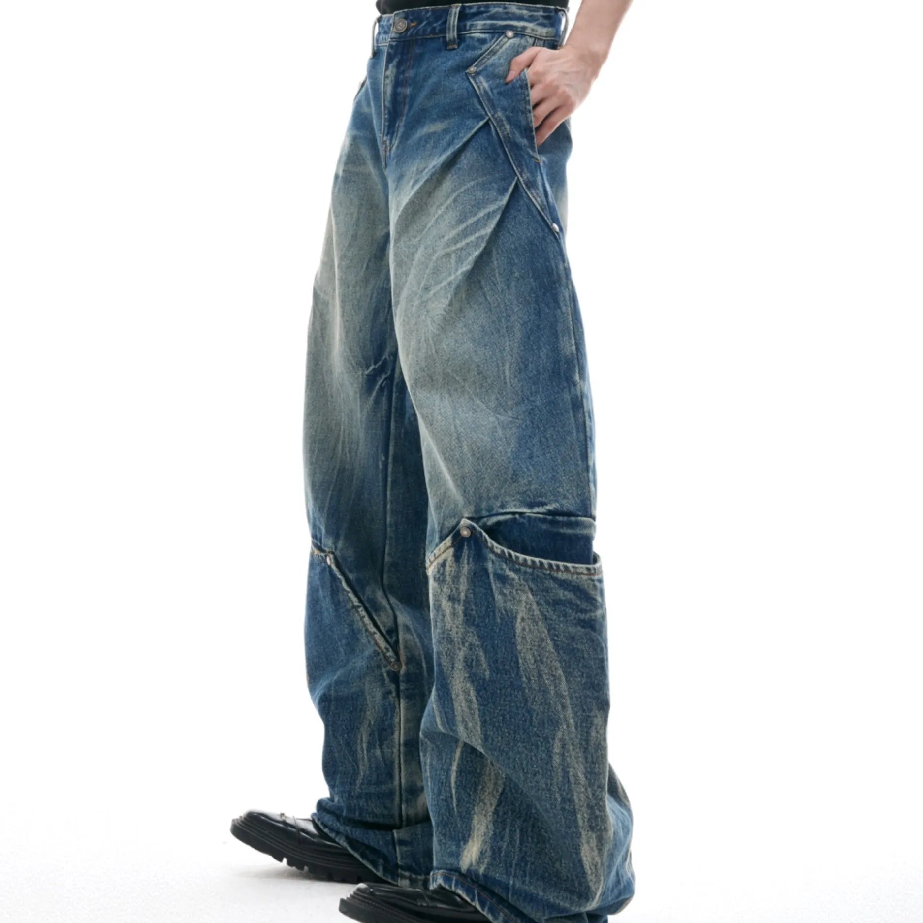 Man wearing verdant blue loose-fit retro jeans with a washed burst pattern.