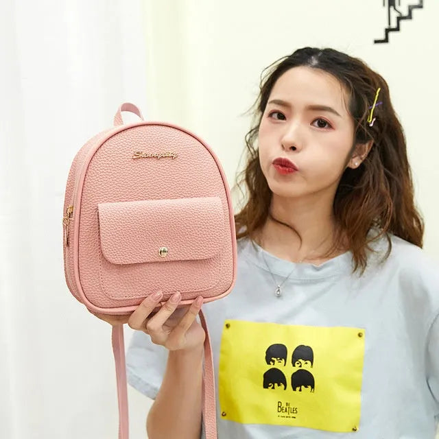Compact black PU leather women's small backpack with a slim profile and zipper closure.