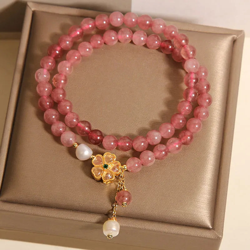 Double ring women's bracelet with strawberry quartz four-leaf clover charms and alloy gemstone details.