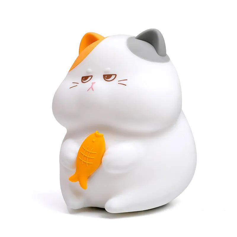 Small greedy cat cartoon desktop night light with yellow fin tuna design on a desk.