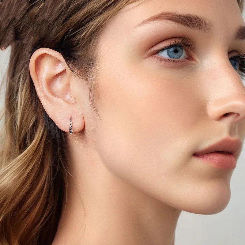 Close-up of S925 sterling silver rhombus earrings with diamond plaid pattern on a neutral background