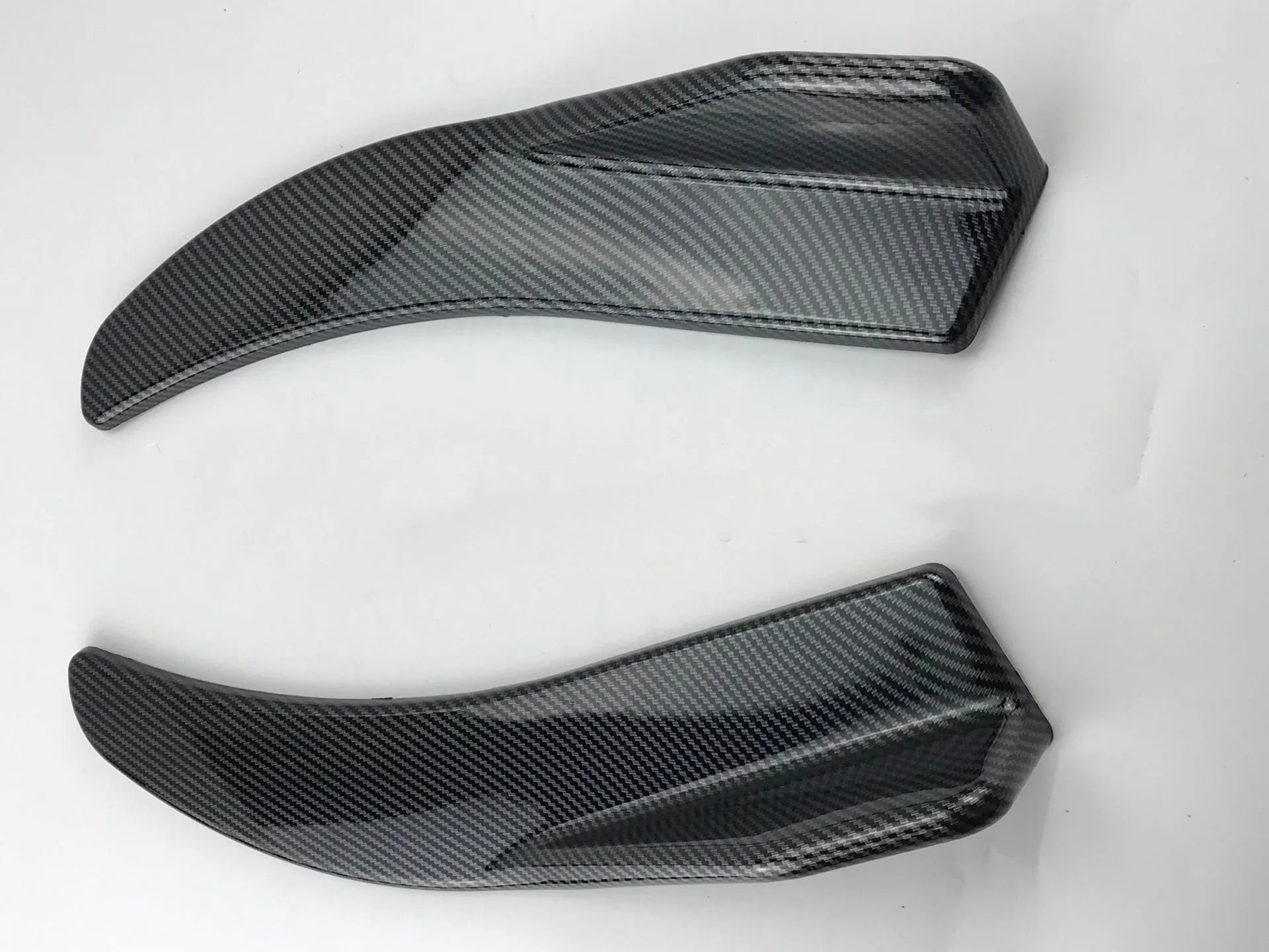 Front and rear car deflector kit for GM vehicles in black and carbon fibre finishes.