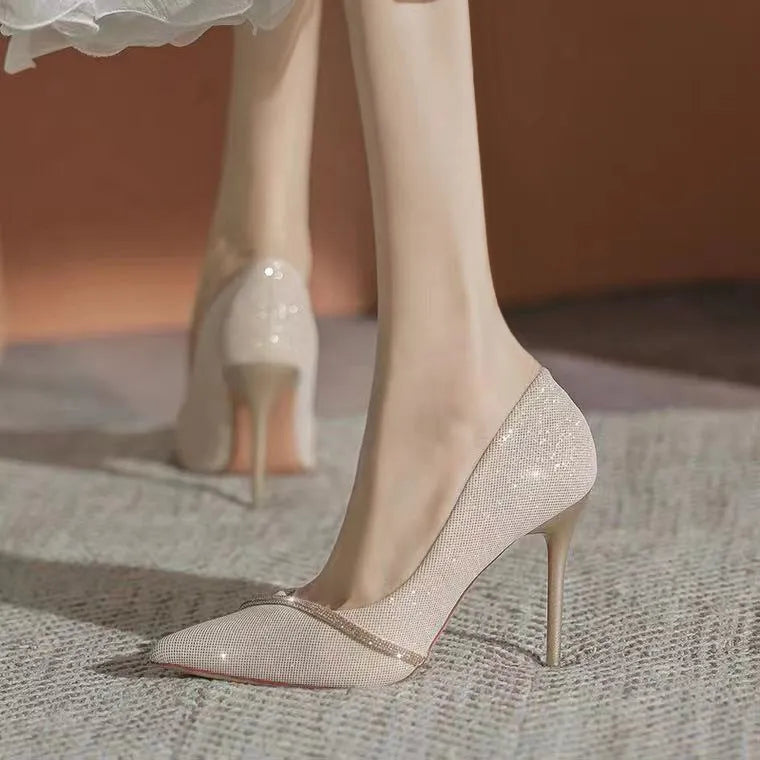 Women's black pointed toe stiletto high heels with a low-cut vamp on a white background