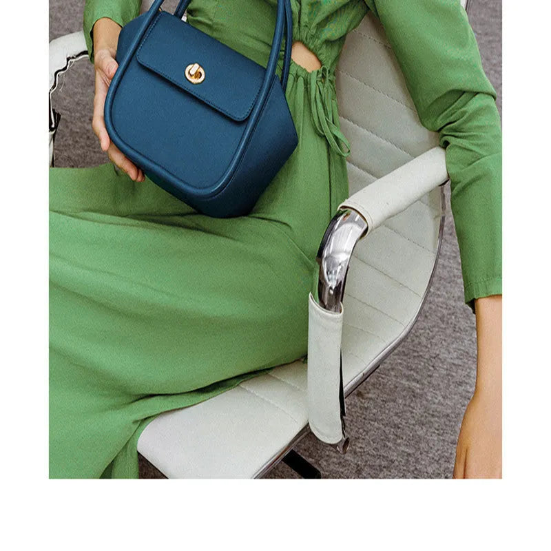 Women's leather wing shape tote bag with cross-body strap in four colour options showing buckle detail
