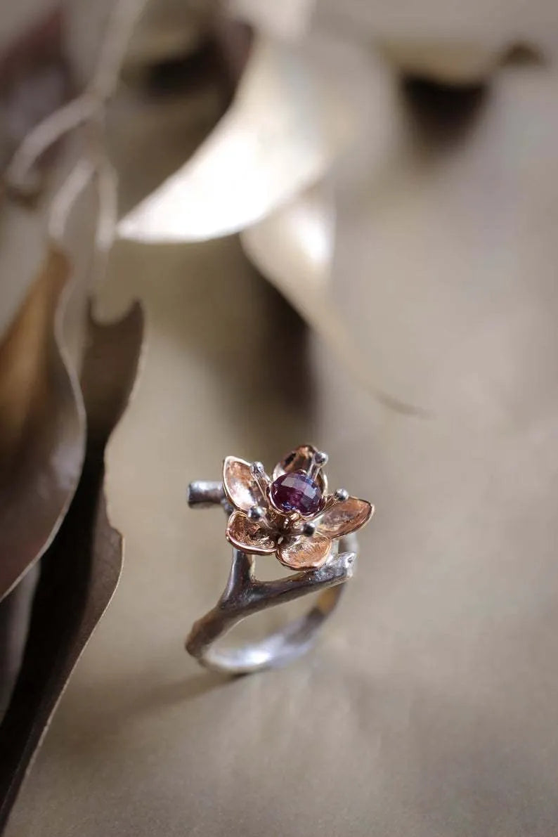 A two-tone silver women's ring with a geometric band and a floral ornament.