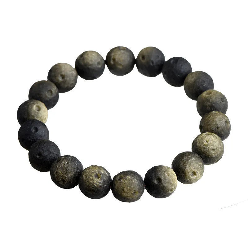 Natural obsidian crater ball bracelet with textured beads in gold or silver stone finish on a wrist.