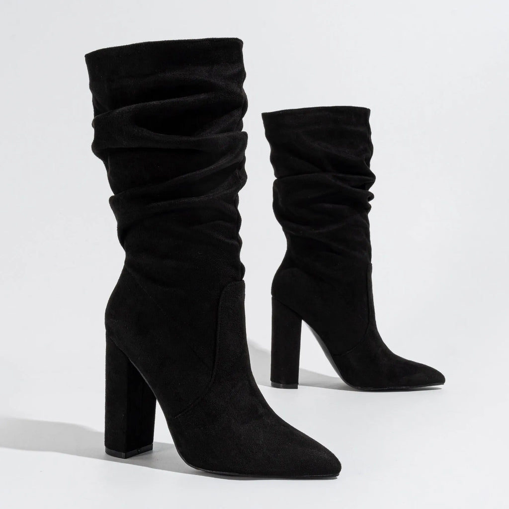 Women's black suede pointed-toe boots with a chunky high heel and pile-style ankle cuff.