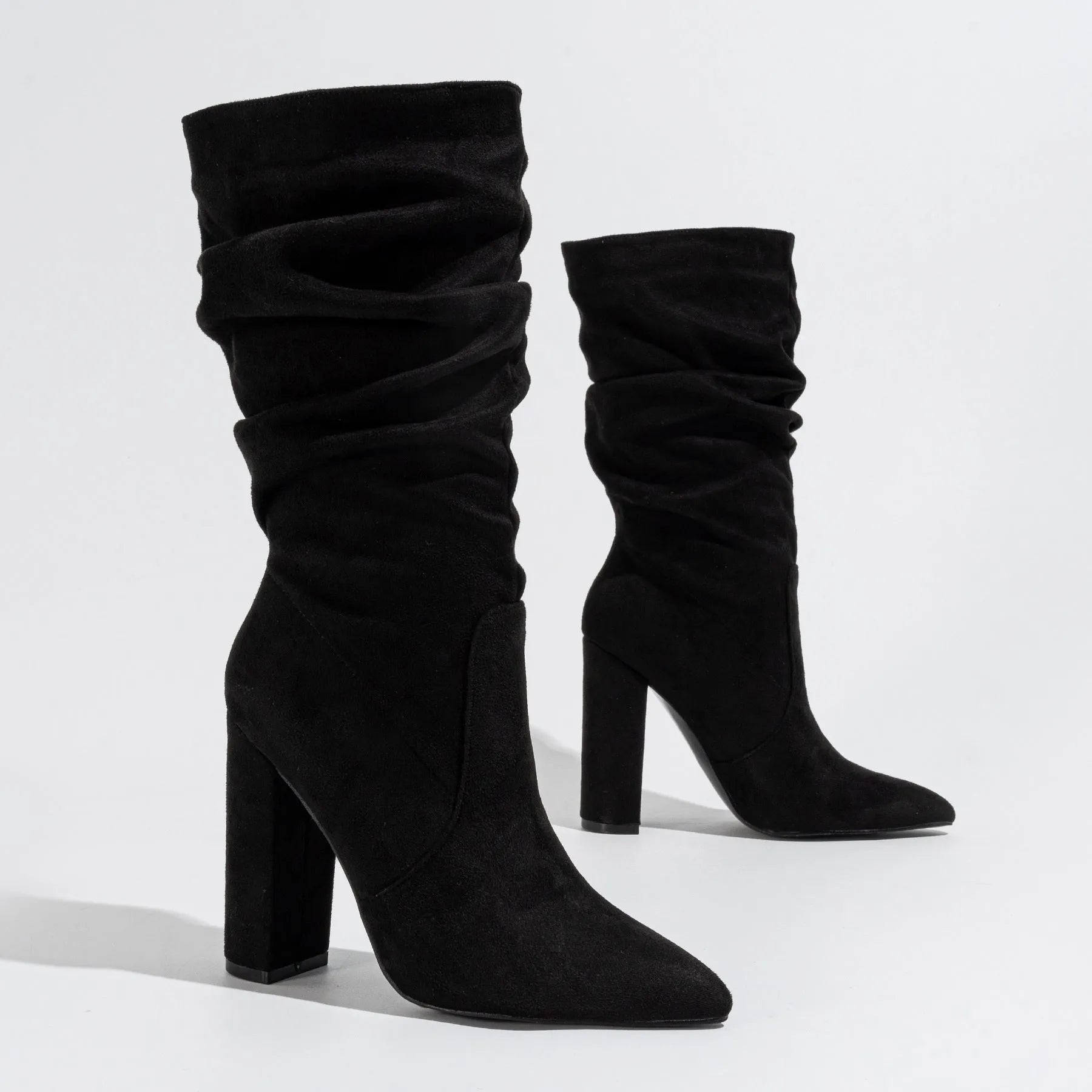 Women's black suede pointed-toe boots with a chunky high heel and pile-style ankle cuff.