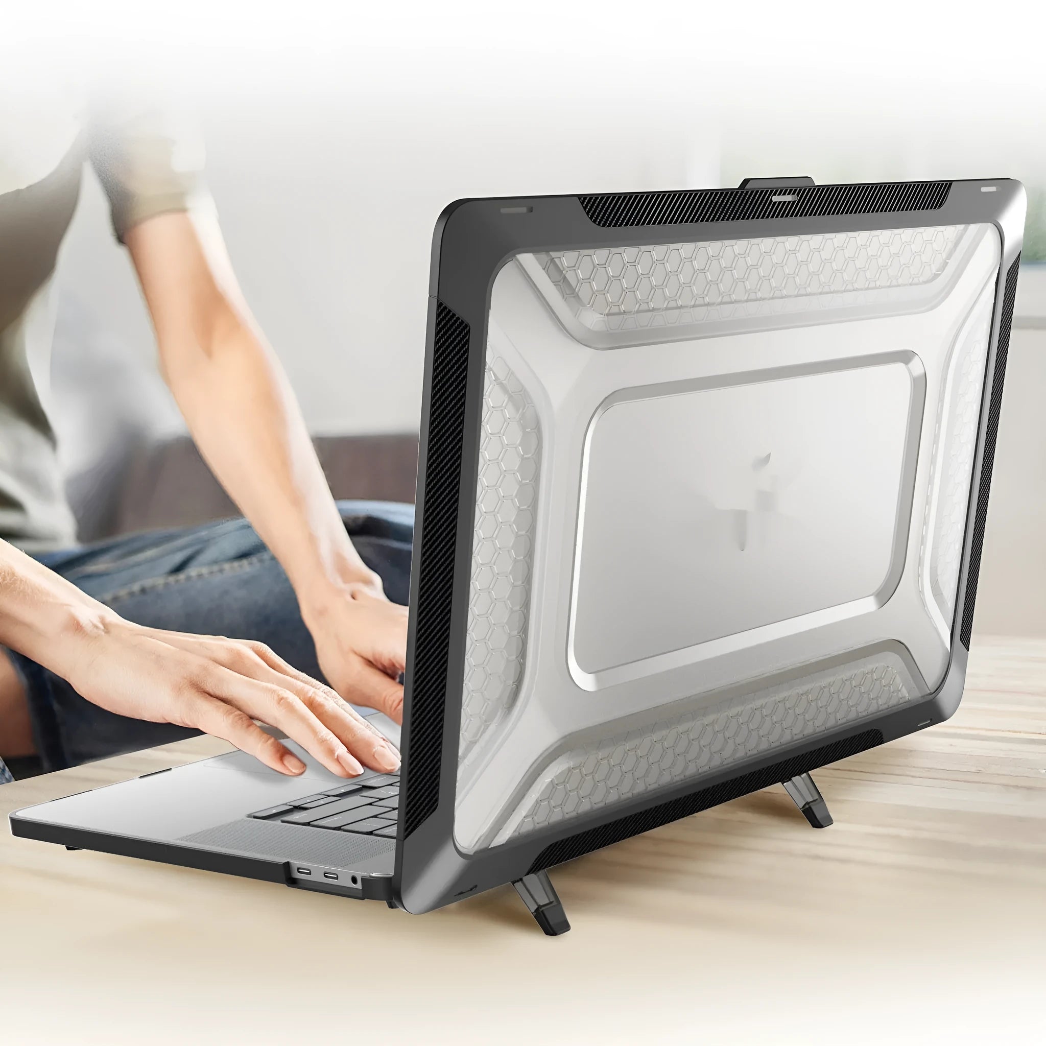 MacBook hard shell protective case in four colours: black, grey, apricot, and blue, shown on a laptop.