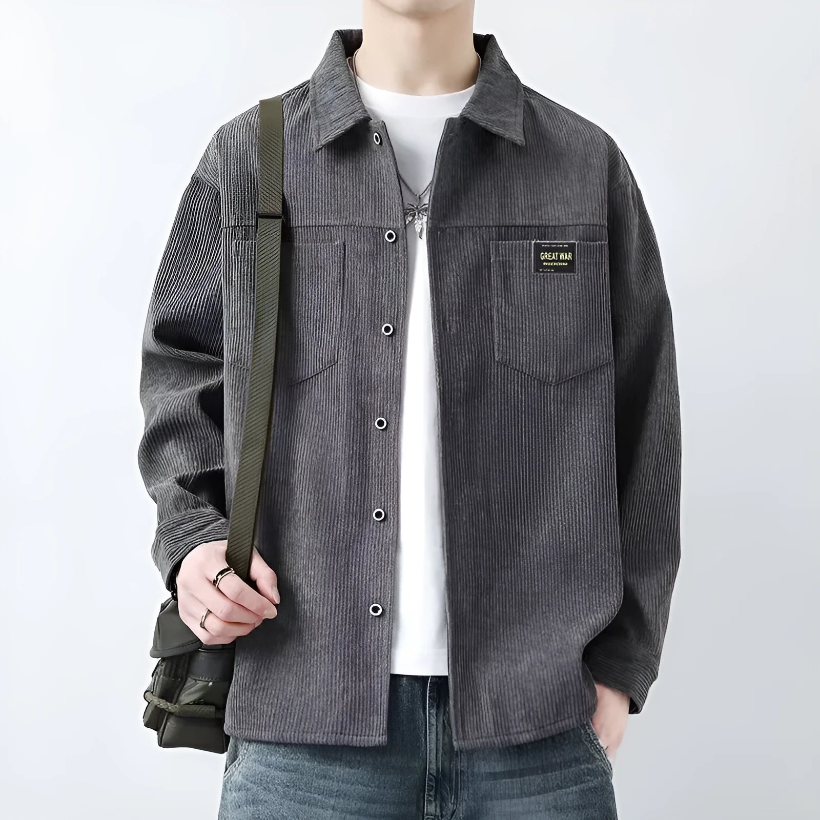 Man wearing a dark grey corduroy cardigan-style jacket with long sleeves.