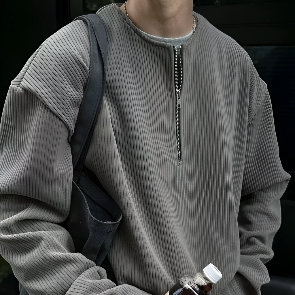 A grey women's loose-fitting long sleeve pullover top with a small letter pattern, shown on a hanger.