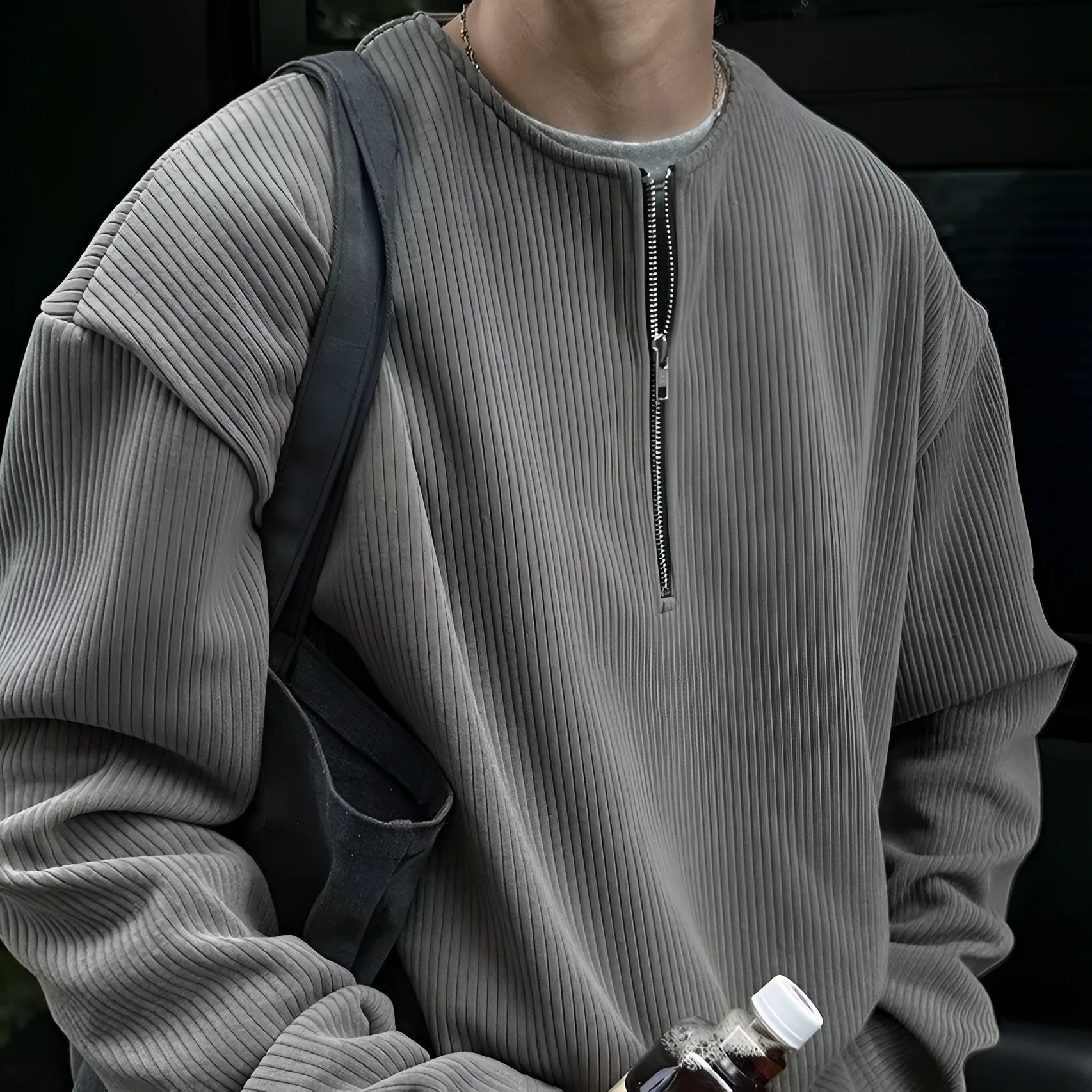 A grey women's loose-fitting long sleeve pullover top with a small letter pattern, shown on a hanger.