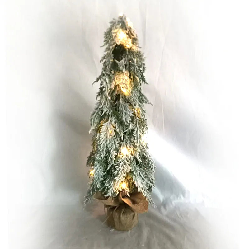 Small 24-inch frosted artificial Christmas tree with LED lights on a desktop.