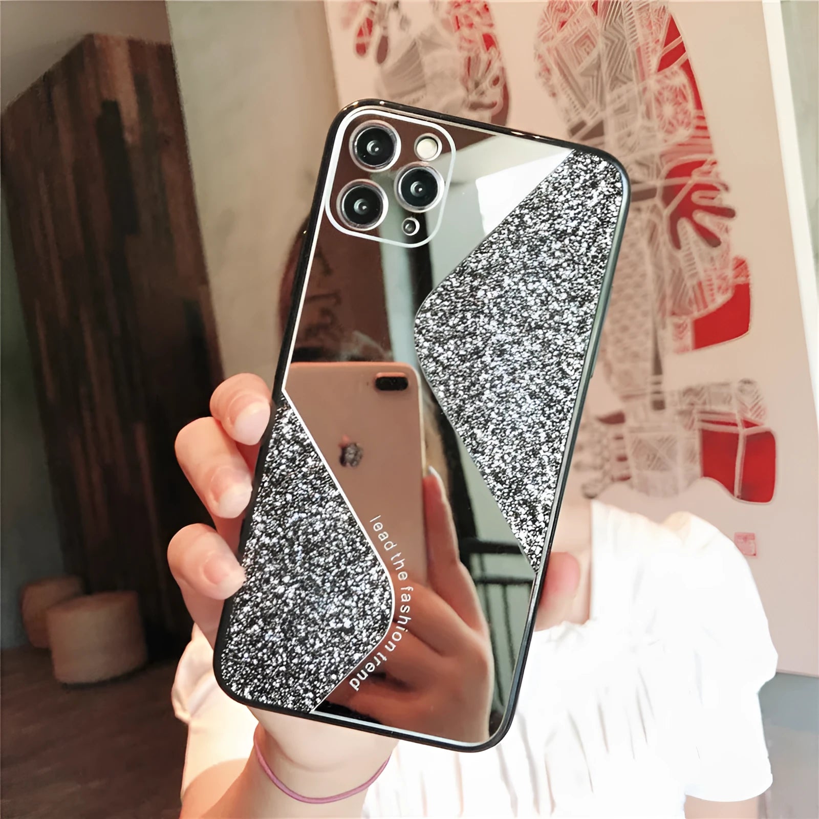 A glitter mirror finish iPhone case with personalised rhinestone detailing, shown in black, blue, and pink colours.