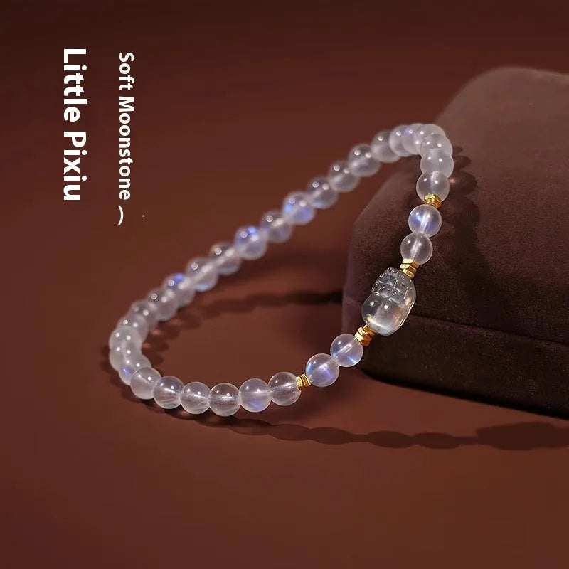 Close-up of a moonstone bracelet with a carved animal or zodiac design, showing grinding finish and blue light trend detail.