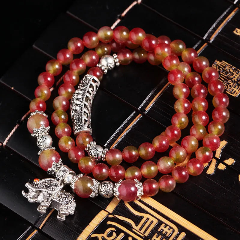 Natural watermelon crystal bracelet with Chinese knot design showing elephant style beads