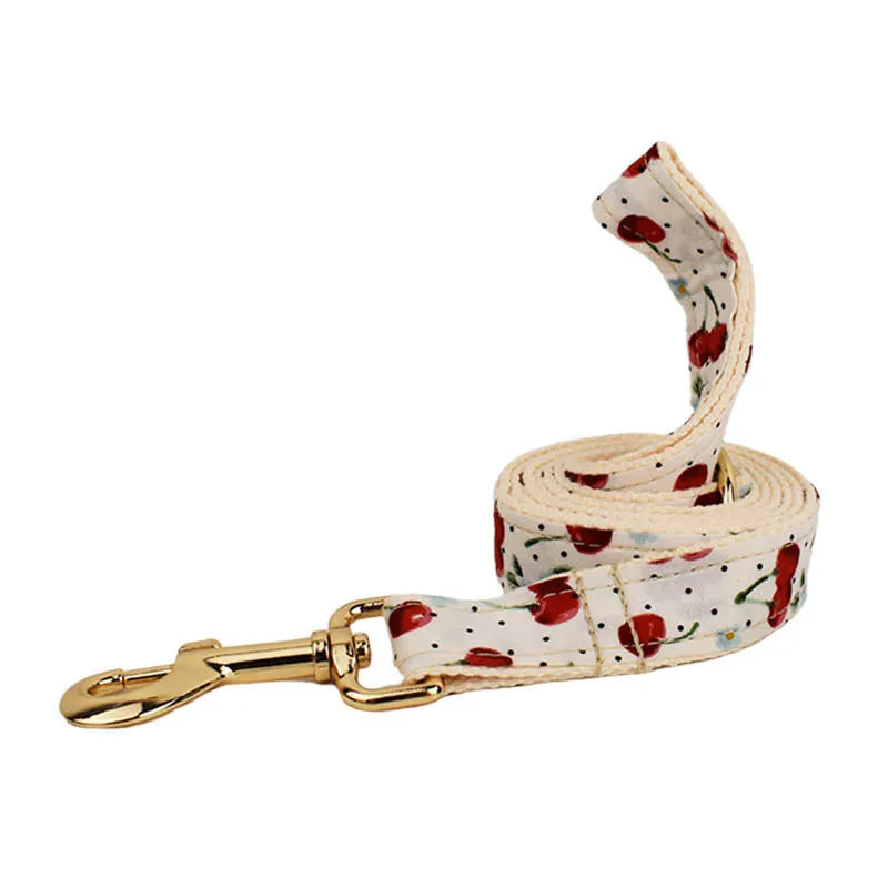 Red cherry print cloth dog collar with light gold release buckle, part of a five-piece pet accessory set.