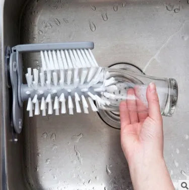 Grey kitchen cleaning brush with two brush heads and suction cups for wall mounting