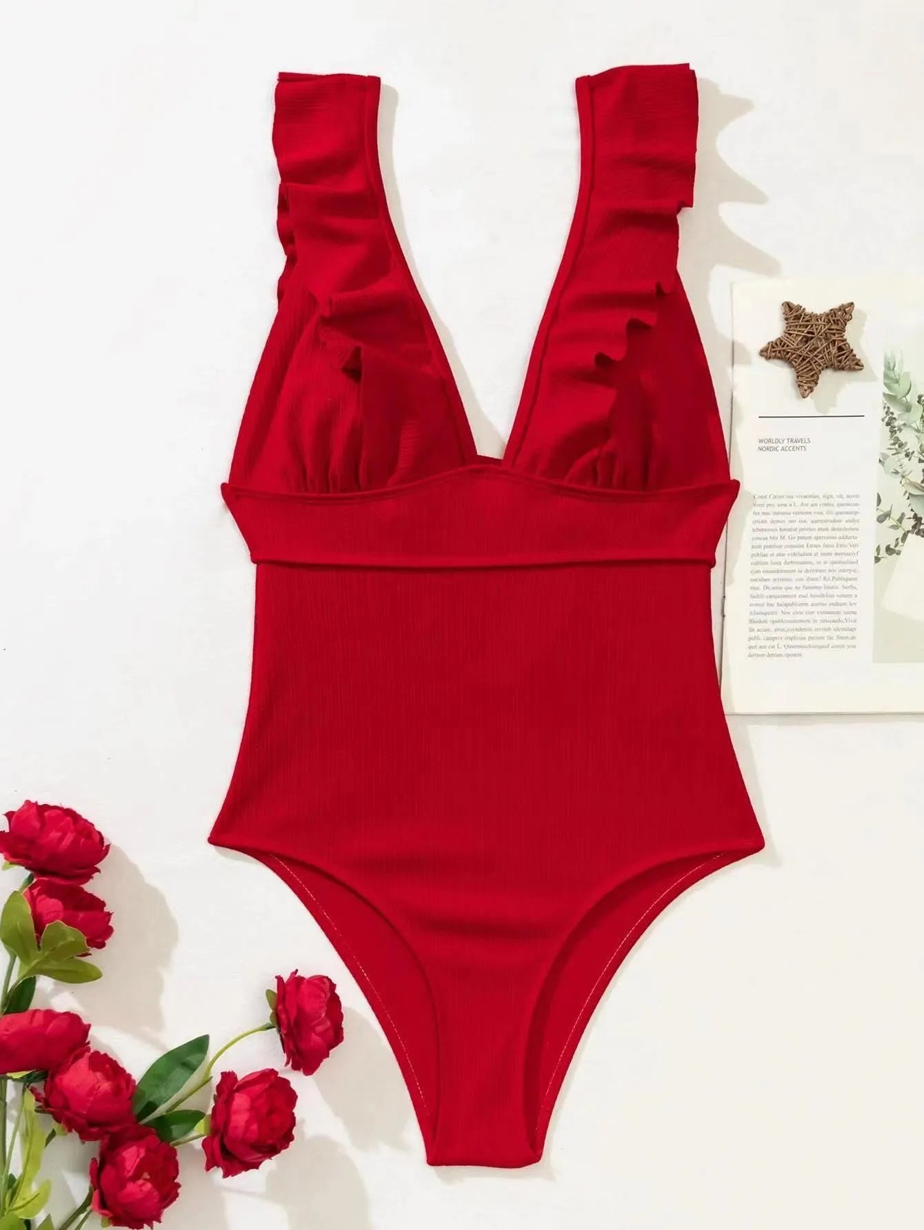 Black one-piece swimsuit for women with ruffled shoulder straps and decorative lace across the back.