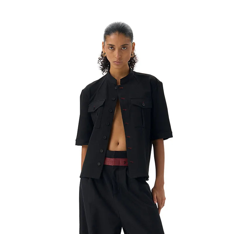 Black handmade loose-fit half sleeve hunting shirt with a shirt collar on a hanger.