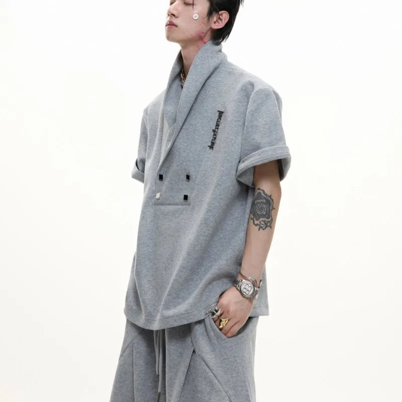Men's dark grey V-neck short sleeve cotton sports jacket with padded shoulders and metal details, paired with matching shorts.