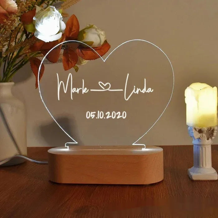 Custom acrylic night light with engraved names and date, lit by LED base.
