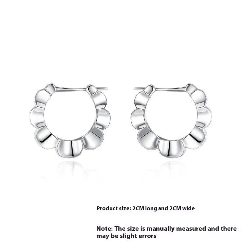 A pair of sterling silver geometric earrings with a round retro design.