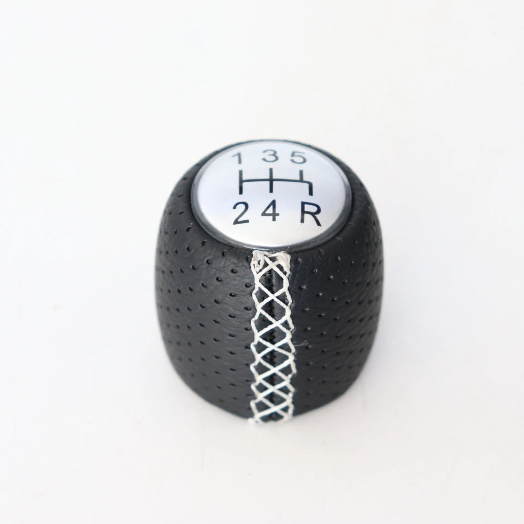 Sewn wrapped perforated leather gear knob for Alpha car in black, red, or white with matte or silver cover.